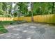 Spacious concrete pad with basketball hoop located in backyard featuring a wooden fence and mature trees at 3003 Maple Ln, Alpharetta, GA 30009