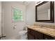 Bathroom features a window, granite counters, framed mirror, and traditional fixtures at 3003 Maple Ln, Alpharetta, GA 30009