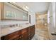 Bathroom featuring double vanity, large mirror, and a glass-enclosed shower with decorative tile accents at 3003 Maple Ln, Alpharetta, GA 30009