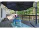 Back deck area featuring an umbrella for shade, surrounded by lush trees and a wooden fence at 3003 Maple Ln, Alpharetta, GA 30009