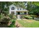 Lovely two-story home featuring a covered front porch and surrounded by lush landscaping and mature trees at 3003 Maple Ln, Alpharetta, GA 30009