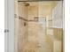 Shower with glass door and bench, featuring stone tile and a niche for storage at 3003 Maple Ln, Alpharetta, GA 30009