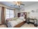 Cozy bedroom with a decorative ceiling fan, plush bed, and bright natural light at 375 Tambec Nw Trce, Lilburn, GA 30047