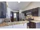 An open kitchen displays stainless appliances, dark cabinets, and granite countertops at 375 Tambec Nw Trce, Lilburn, GA 30047