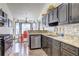 Modern kitchen featuring dark cabinetry, stainless steel appliances, and granite countertops at 375 Tambec Nw Trce, Lilburn, GA 30047