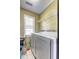 Compact laundry area with a window, washer, dryer, and shelving for storage at 375 Tambec Nw Trce, Lilburn, GA 30047