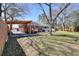 Backyard view of a brick home with deck and covered porch under a blue sky at 4212 Logan Dr, Loganville, GA 30052
