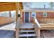 Wooden deck and stairs leading to a brick home with a black door and wood railing at 4212 Logan Dr, Loganville, GA 30052