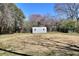 Spacious backyard with shed and mature trees under a clear blue sky at 4212 Logan Dr, Loganville, GA 30052