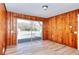 Living room with wood paneling, sliding glass door to deck, and access to other rooms at 4212 Logan Dr, Loganville, GA 30052