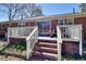 Brick steps leading to a cozy patio area with a picnic table and white railing at 4212 Logan Dr, Loganville, GA 30052
