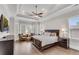 A main bedroom features tray ceilings, hardwood flooring, and a large bed with an ensuite bathroom at 4850 Kentwood Dr, Marietta, GA 30068