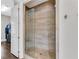 This elegant walk-in shower features pebble flooring, vertical tile and a frameless glass door at 4850 Kentwood Dr, Marietta, GA 30068