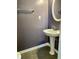 Powder room featuring a pedestal sink, chrome towel bar, and a round mirror at 2199 Ramblewood Cir, Decatur, GA 30035