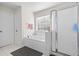 Bright bathroom features a soaking tub, frosted glass shower door and a window with blinds for natural light and privacy at 2283 Shady Maple Ln, Loganville, GA 30052