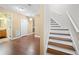 Hallway with hardwood floors, featuring access to the bathroom, stairs to second floor, and a closet for storage at 2283 Shady Maple Ln, Loganville, GA 30052