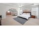Spacious main bedroom featuring a tray ceiling, ceiling fan, and a sitting area with a dresser at 2283 Shady Maple Ln, Loganville, GA 30052