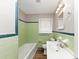 Classic bathroom featuring green tiled walls, white fixtures, and vintage-inspired design at 4281 Welbron Dr, Decatur, GA 30035
