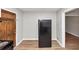 View of black refrigerator and hardwood floor next to rustic wooden door at 4281 Welbron Dr, Decatur, GA 30035