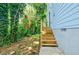 Backyard with new wooden stairs leading up to the house. Landscape is lush and green at 813 Smith Sw St # B, Atlanta, GA 30310