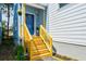 Inviting front porch with wooden stairs, railing, and a pop of color on the front door at 813 Smith Sw St # B, Atlanta, GA 30310