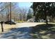 Charming home featuring a gravel driveway, lush trees, and a well-maintained lawn at 2184 E Cherokee Dr, Woodstock, GA 30188
