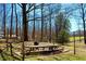 Charming backyard picnic area with rustic table, string lights, and a beautiful wooded backdrop at 2184 E Cherokee Dr, Woodstock, GA 30188