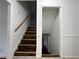 Staircase with hardwood steps and white trim leading to the basement, freshly painted with newel post at 2717 Rosemont Dr, Lawrenceville, GA 30044