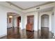 Open concept living area with hardwood floors and arched doorways to kitchen and hallway at 3445 Stratford Ne Rd # 502, Atlanta, GA 30326