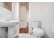 Small bathroom features a white toilet and sink, with tile walls and flooring at 3542 W Hill St, Clarkston, GA 30021