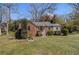 Inviting brick home with lush green lawn, mature trees, and quaint front porch at 3542 W Hill St, Clarkston, GA 30021
