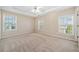 Bedroom featuring neutral carpet, a ceiling fan, and multiple windows for natural light at 1296 Park Pass Way, Suwanee, GA 30024