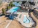 Aerial view of a community pool, clubhouse, lounge chairs, and manicured landscaping at 1296 Park Pass Way, Suwanee, GA 30024