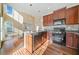Bright kitchen features hardwood floors, tile backsplash, stainless steel appliances, and a kitchen island at 1296 Park Pass Way, Suwanee, GA 30024