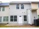 Rear view of a two-story house with access to a concrete patio and fenced backyard at 247 Brookview Dr, Riverdale, GA 30274