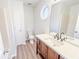 Updated bathroom featuring a round window, a vanity with a faucet, neutral paint and flooring at 247 Brookview Dr, Riverdale, GA 30274