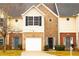 Charming townhome featuring brick and siding facade, single car garage and front lawn at 247 Brookview Dr, Riverdale, GA 30274