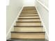 Ascending staircase featuring treads in a light wood finish, black trim, and white risers and railing at 247 Brookview Dr, Riverdale, GA 30274