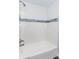 Clean shower with white subway tile and a decorative glass tile accent stripe at 2598 Elliott Nw St, Atlanta, GA 30318
