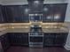 Modern kitchen with stainless steel appliances, dark wood cabinets, and granite countertops at 404 Providence Walk St, Canton, GA 30114