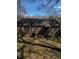 View of a brick house backyard with overgrown plants and a dark shadow at 2319 Browns Mill Se Rd, Atlanta, GA 30315