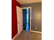 A carpeted bedroom with red and gray walls, featuring an open white paneled door at 6682 Biscayne Blvd, Rex, GA 30273