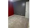 A carpeted bedroom featuring red and gray walls and a white paneled door at 6682 Biscayne Blvd, Rex, GA 30273
