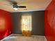 A carpeted bedroom featuring red and gray walls, and a ceiling fan at 6682 Biscayne Blvd, Rex, GA 30273