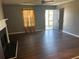 A gray-walled living room with wood flooring, a ceiling fan, a fireplace, and a door to the outside at 6682 Biscayne Blvd, Rex, GA 30273
