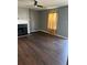 A gray-walled living room with wood flooring, a ceiling fan, and a fireplace at 6682 Biscayne Blvd, Rex, GA 30273
