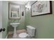 Powder room with pedestal sink, framed art and green walls at 189 Westminster Dr, Atlanta, GA 30309