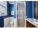 Stylish bathroom with a glass-enclosed shower, marble countertop, vanity, and blue walls accented by white wainscoting at 189 Westminster Dr, Atlanta, GA 30309