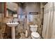 Cozy bathroom with stone tile walls, a pedestal sink, and a standard toilet at 3180 Mathieson Ne Dr # 806, Atlanta, GA 30305