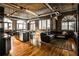 Open-concept living room featuring exposed brick, hardwood floors, and an island with seating at 3180 Mathieson Ne Dr # 806, Atlanta, GA 30305